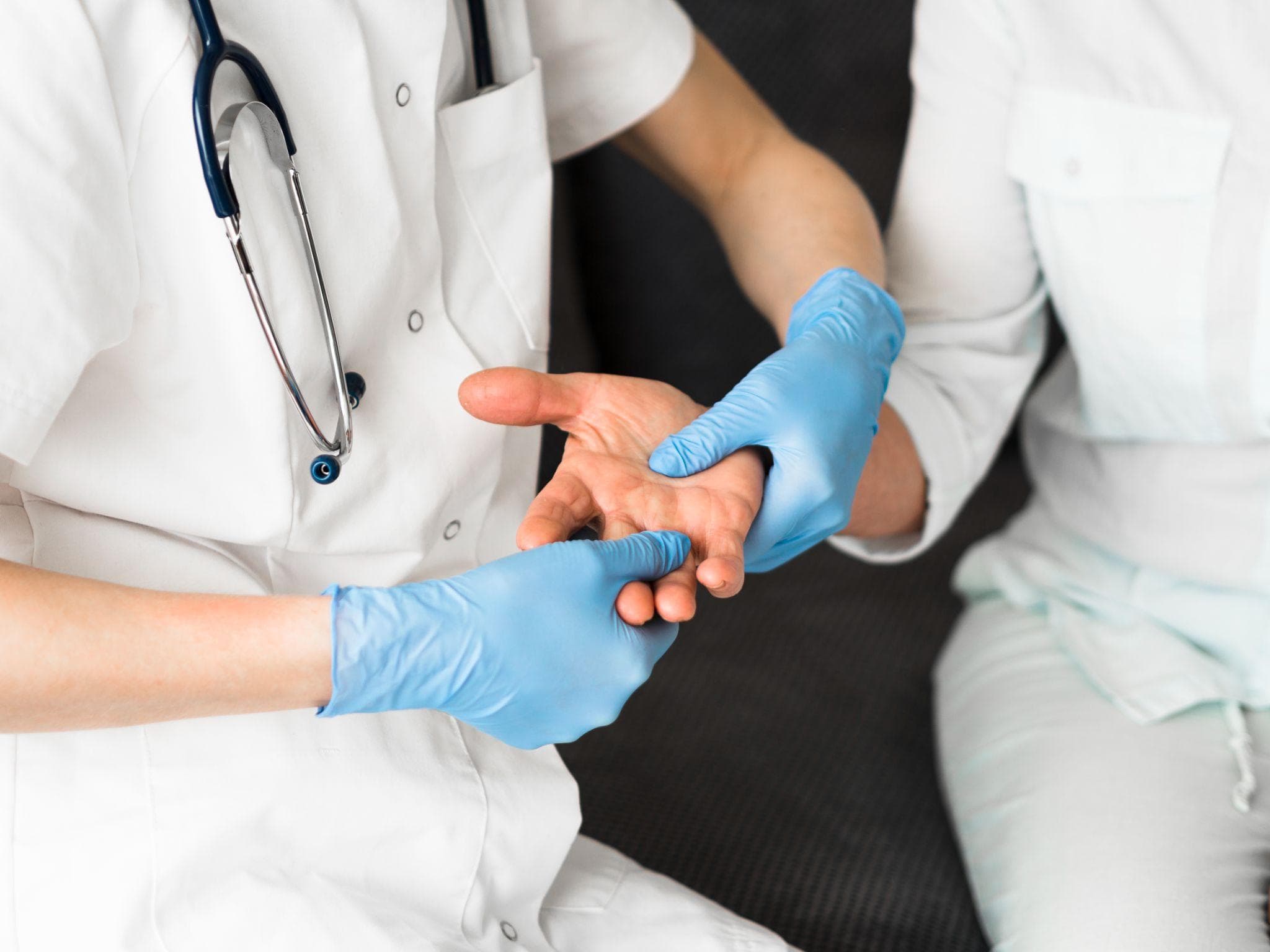 A doctor checking the joints of the hand of the patient in the clinic.