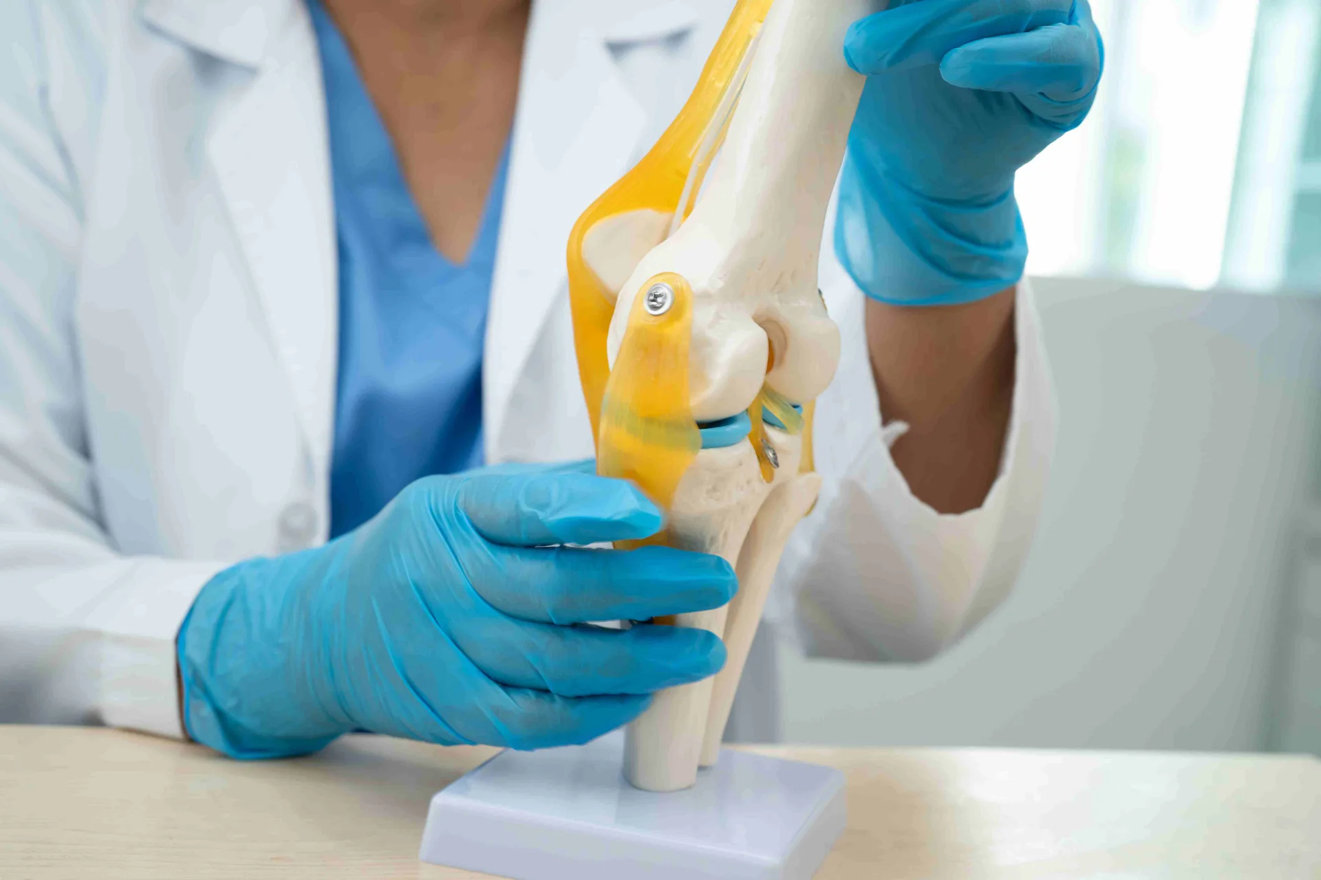 Surgeon showing a knee joint model while explaining types of knee surgery.