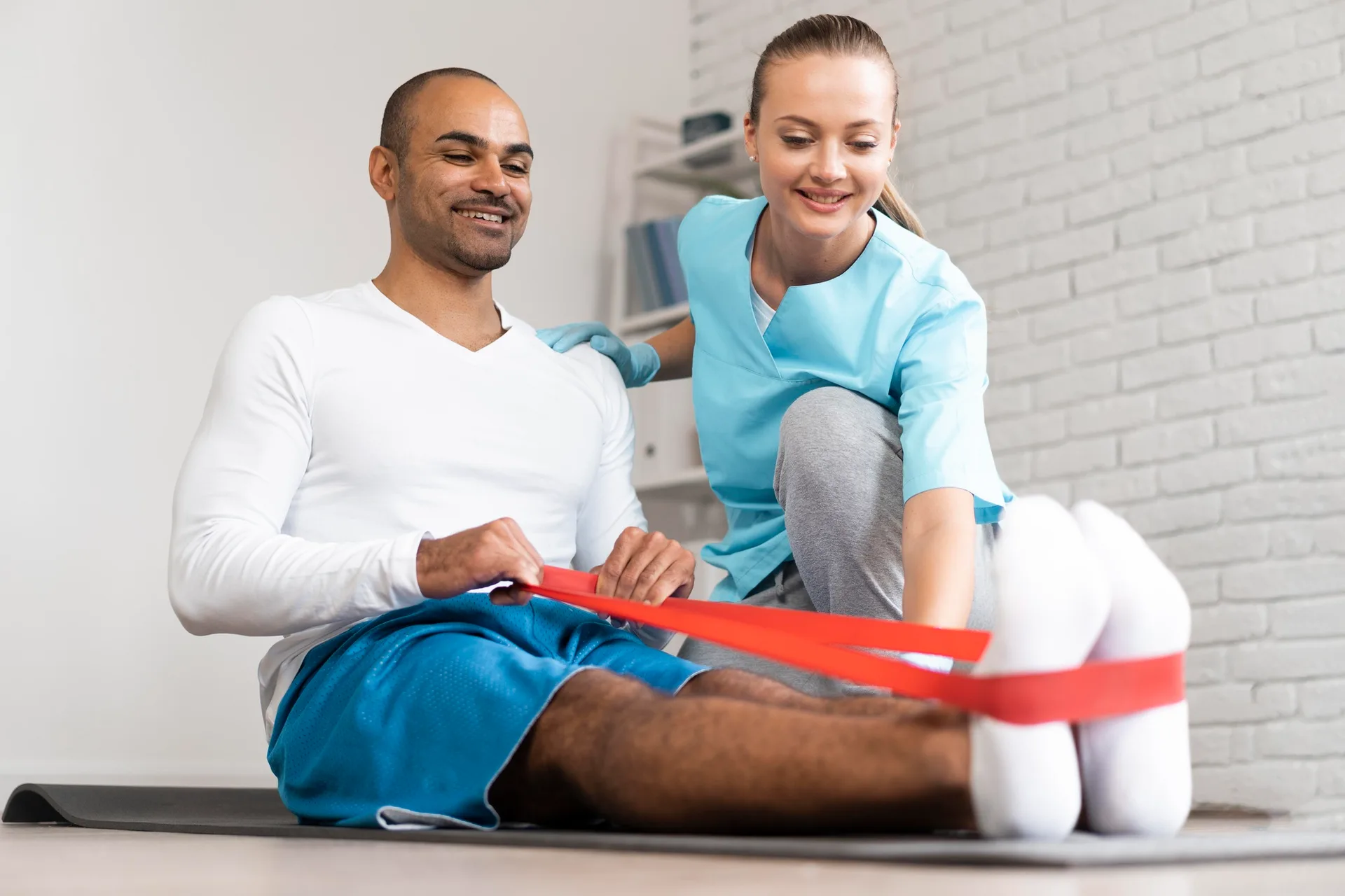 A patient performs supervised leg physiotherapy exercises to regain strength, mobility, and balance after a leg fracture.