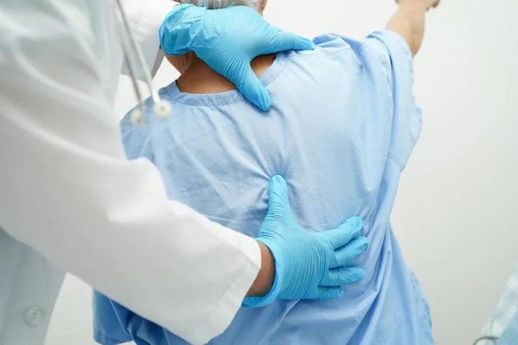 doctor examining a patient’s back.