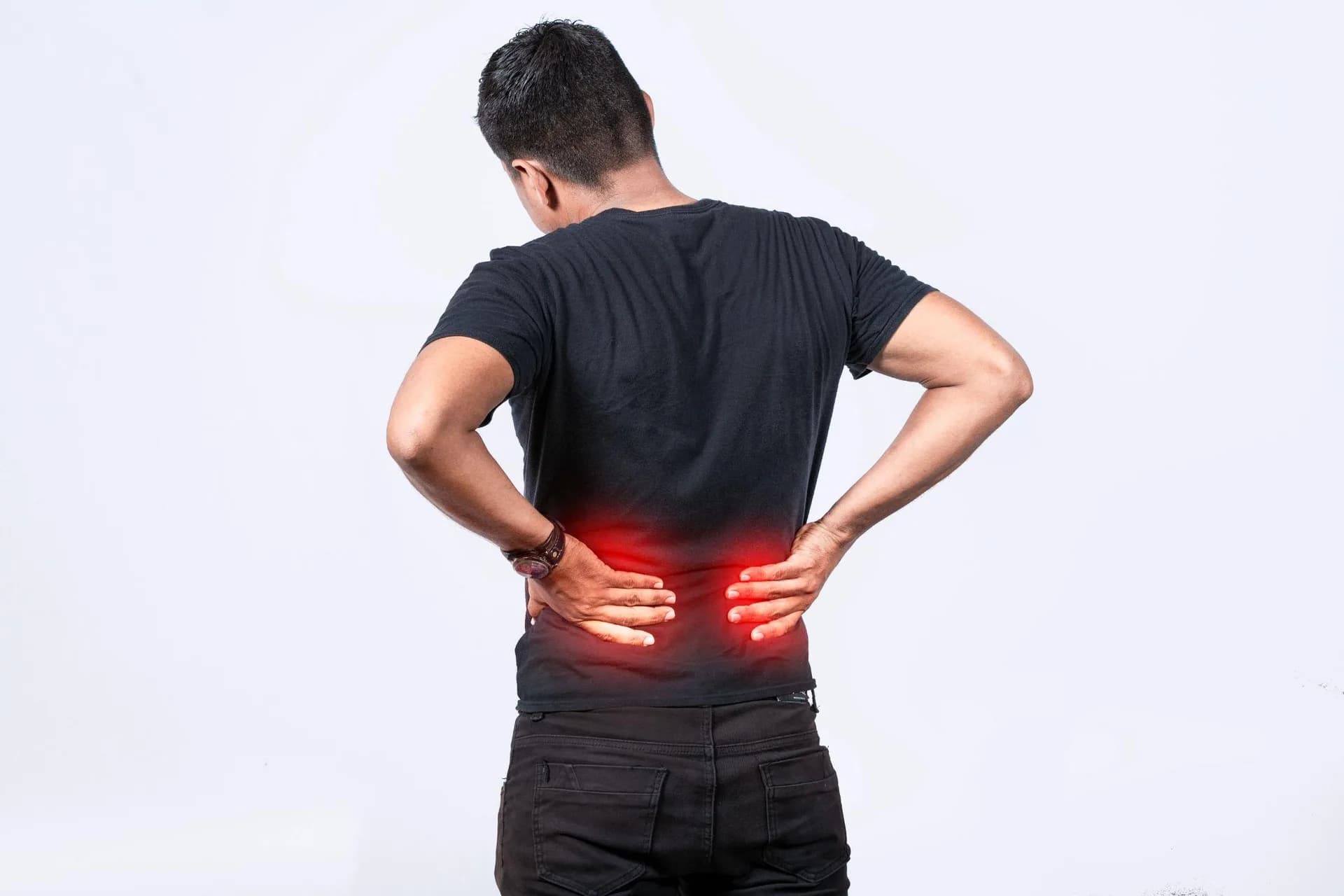 A man holding his lower back due to lumbar pain, representing spine-related problems such as muscle strain or sciatica.